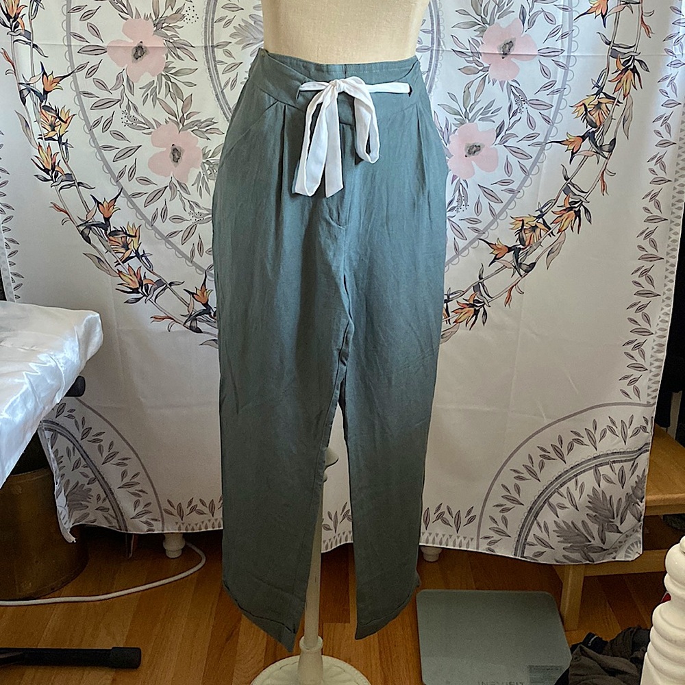 Greenish-gray pants with white drawstring belt. 1” cuff at the hem
